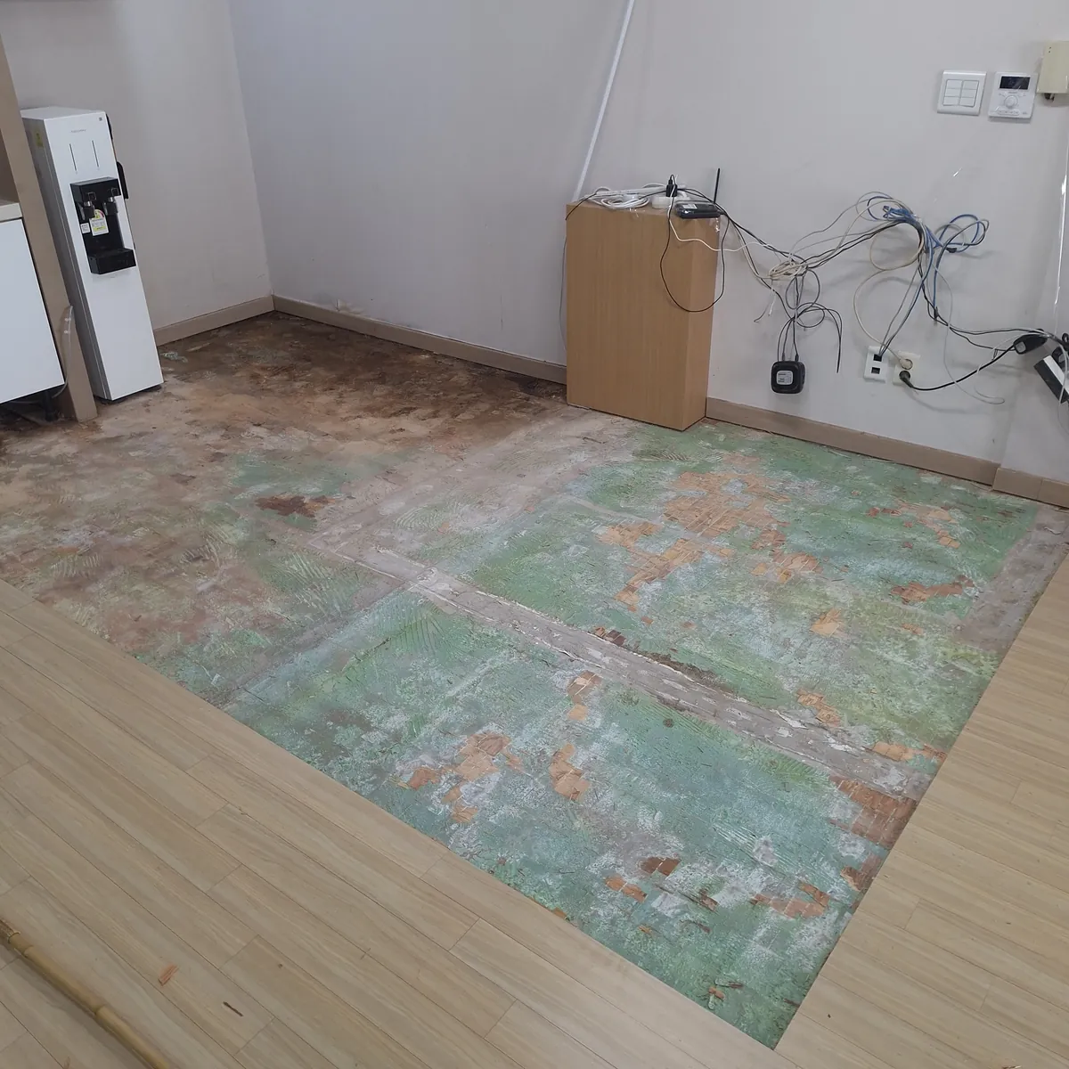 정수기 설치 구역 바닥 정수기 누수로 썩은 강마루 부분 철거 진행 중